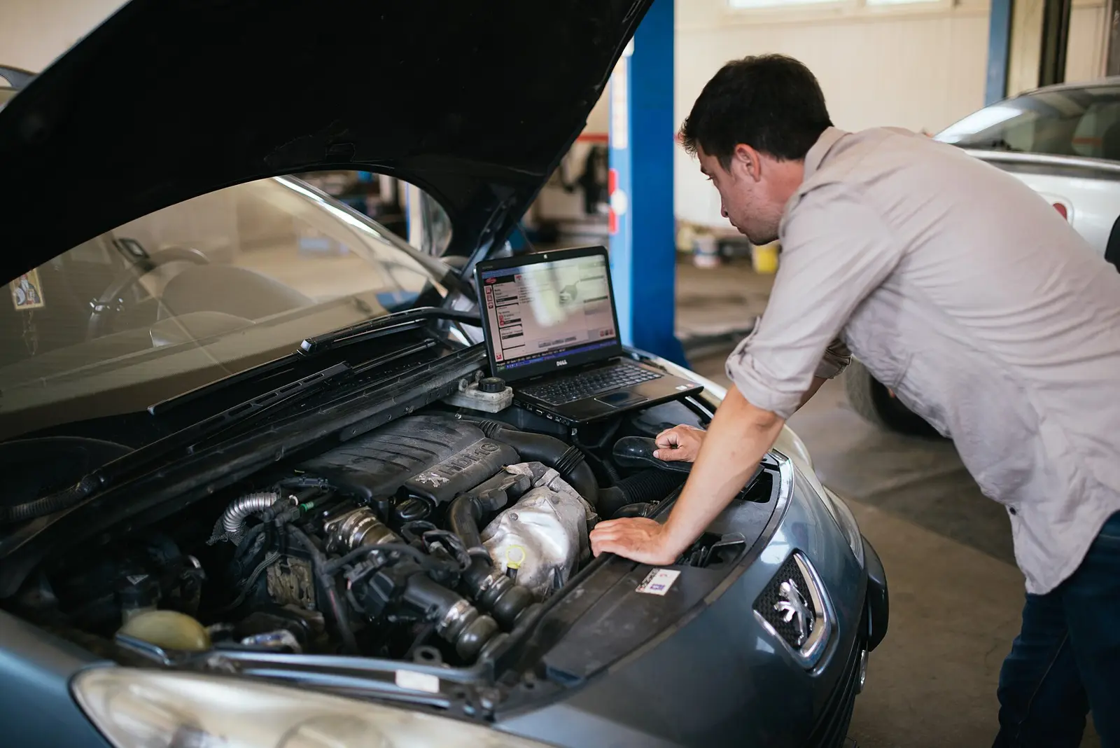 Mechanic running a diagnostic on a laptop