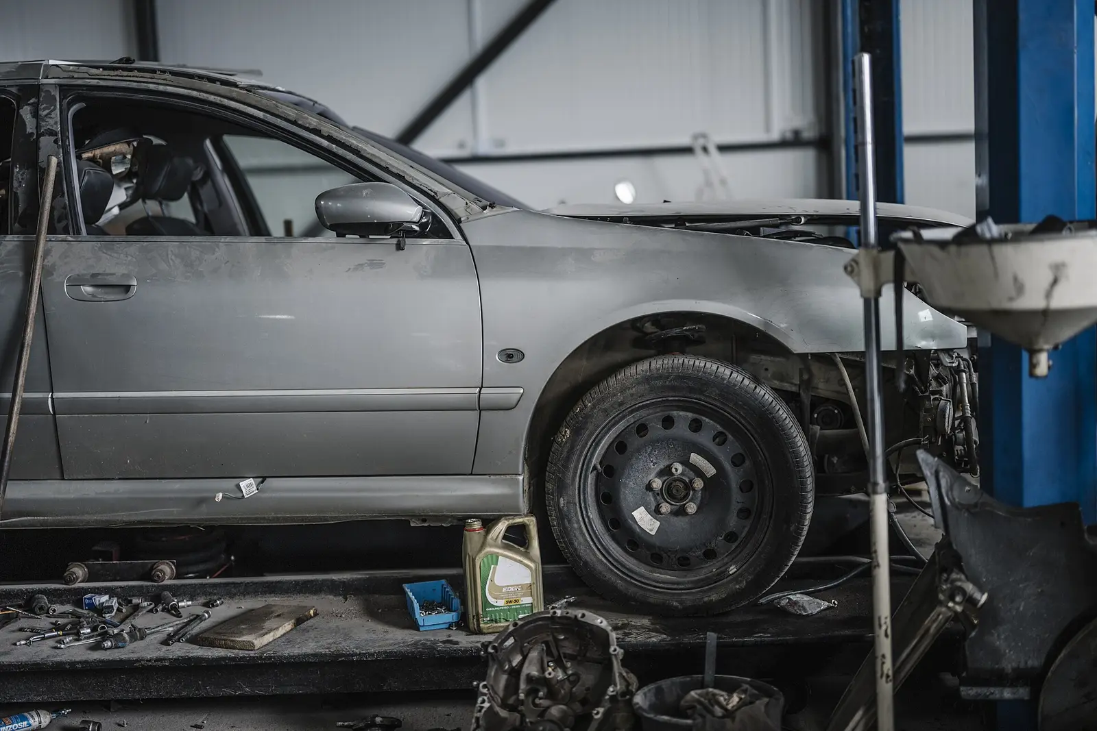 A car on a hoist in a workshop