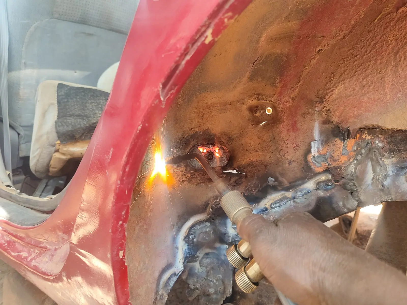 A panel beater repairing a car body